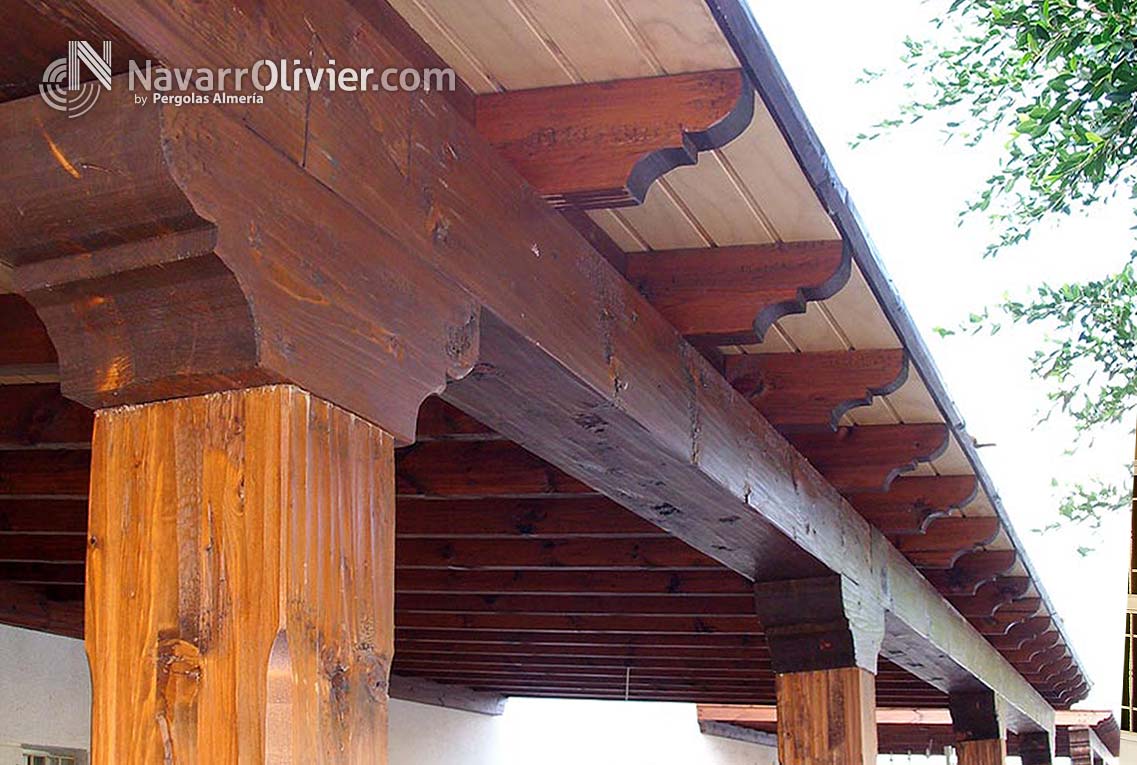 Pergola de madera adosada con pilares rematados en capitel