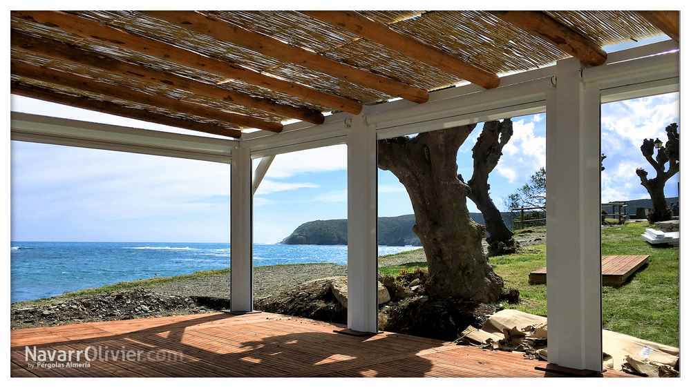 Pergola de madera co techo de tronco y mimbre en Cadaques